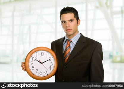 young handsome business man holding a clock