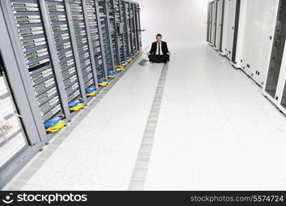 young handsome business man in black suit practice yoga and relax at network server room while representing stress control concept