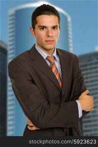 young handsome business man portrait with some office buildings behind