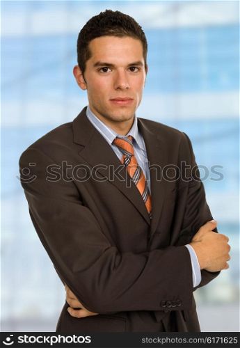 young handsome business man portrait with some office buildings behind