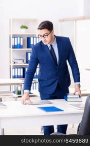 Young handsome businessman employee working in office at desk