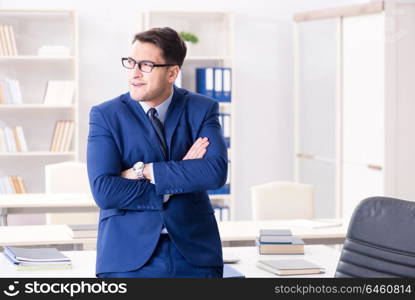 Young handsome businessman employee working in office at desk