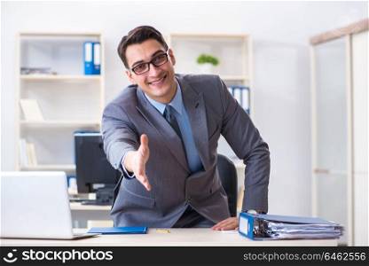 Young handsome businessman employee working in office at desk