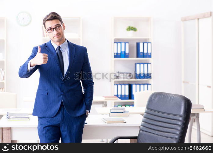 Young handsome businessman employee working in office at desk