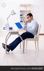 Young handsome businessman employee working in office at desk