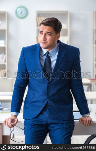 Young handsome businessman employee working in office at desk