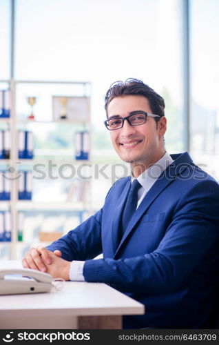 Young handsome businessman employee working in office at desk