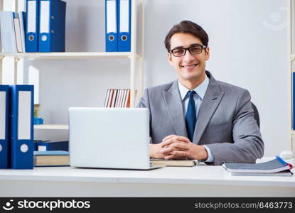 Young handsome businessman employee working in office at desk