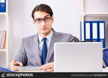 Young handsome businessman employee working in office at desk