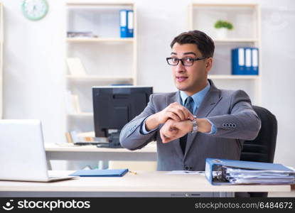 Young handsome businessman employee working in office at desk