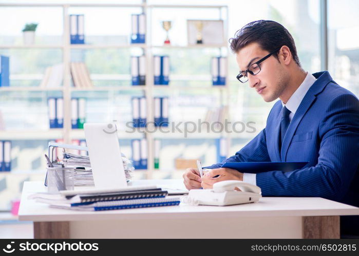 Young handsome businessman employee working in office at desk