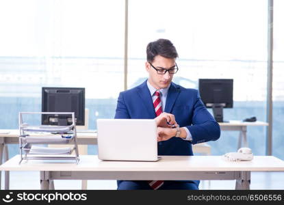 Young handsome businessman employee working in office at desk