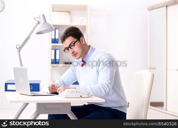 Young handsome businessman employee working in office at desk
