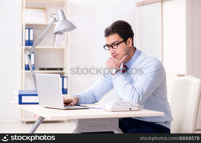 Young handsome businessman employee working in office at desk