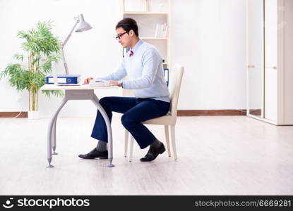 Young handsome businessman employee working in office at desk