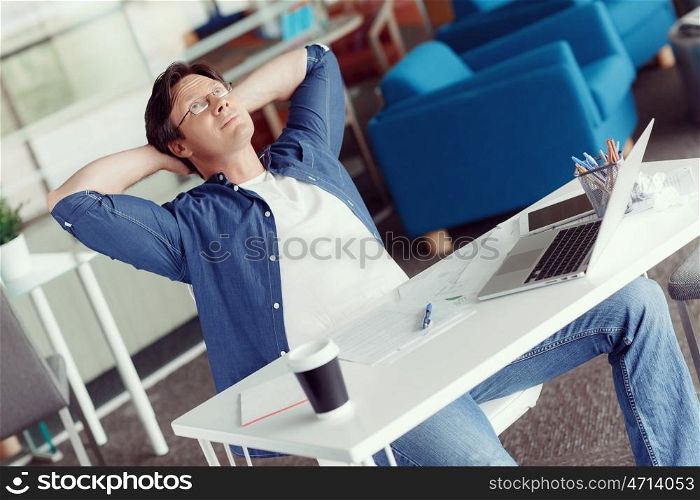 Young handsome businessman in an office having a break