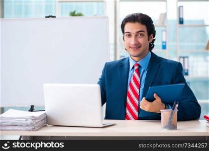 Young handsome businessman in front of whiteboard 
