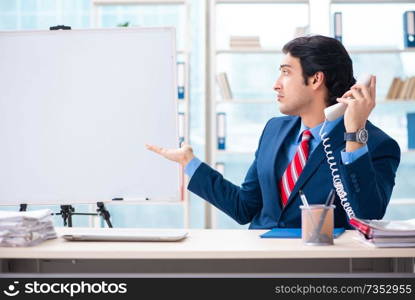 Young handsome businessman in front of whiteboard 