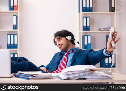 Young handsome businessman sitting in the office  . Young handsome businessman sitting in the office 