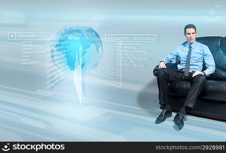 Young handsome businessman sitting on the sofa analyzing data from virtual holographic interface screen.