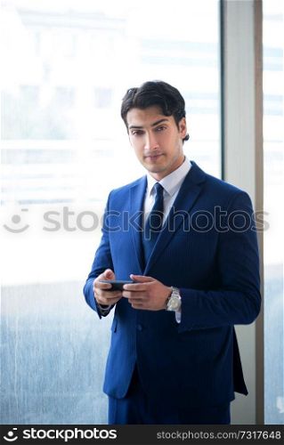 Young handsome businessman standing at the window 