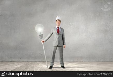 Young handsome businessman wearing white paper crown