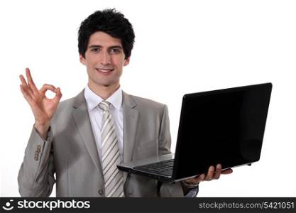 young handsome businessman with laptop making okay sign