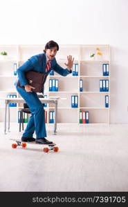 Young handsome businessman with longboard in the office 