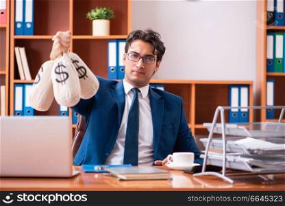 Young handsome businessman working in the office. The young handsome businessman working in the office