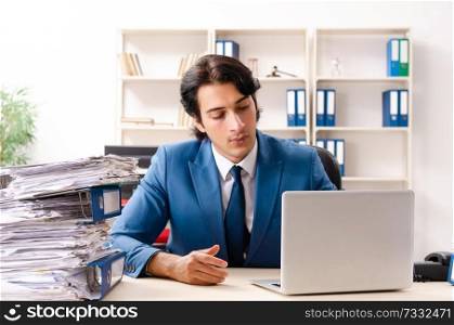 Young handsome busy employee sitting in office  . Young handsome busy employee sitting in office 
