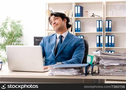 Young handsome busy employee sitting in office  . Young handsome busy employee sitting in office 