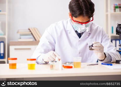 Young handsome chemist working in the lab