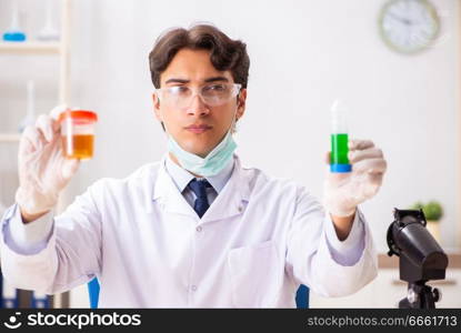 Young handsome chemist working in the lab