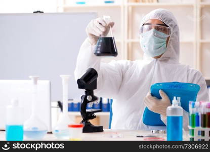 Young handsome chemist working in the lab 