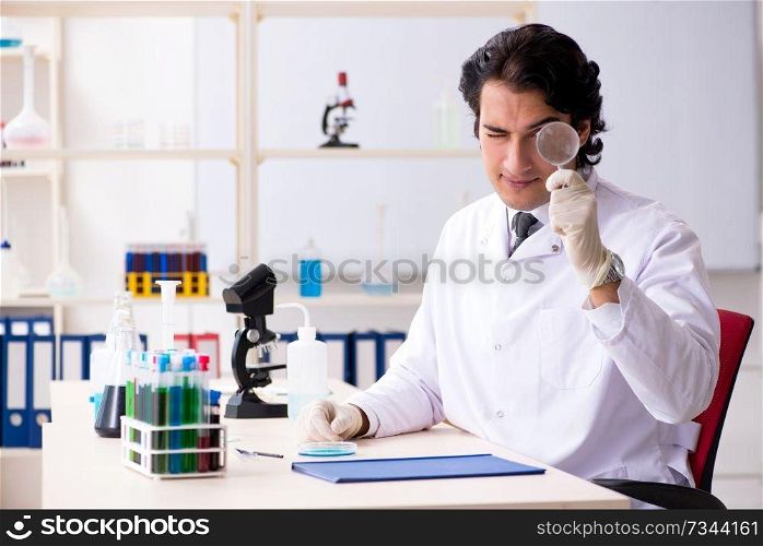 Young handsome chemist working in the lab 