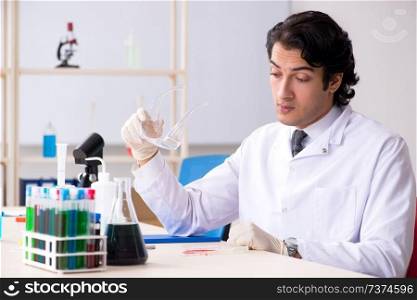 Young handsome chemist working in the lab 