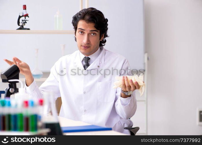 Young handsome chemist working in the lab 