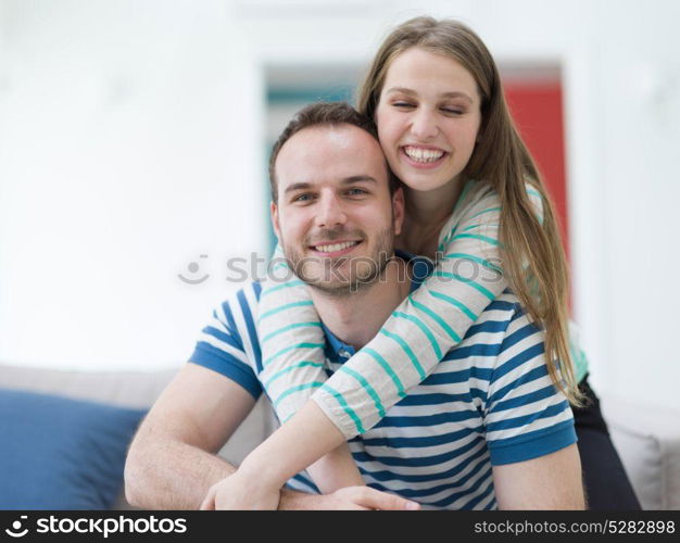 young handsome couple enjoys hugging on the sofa in their luxury home villa