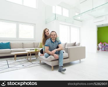 young handsome couple enjoys hugging on the sofa in their luxury home villa