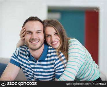 young handsome couple enjoys hugging on the sofa in their luxury home villa
