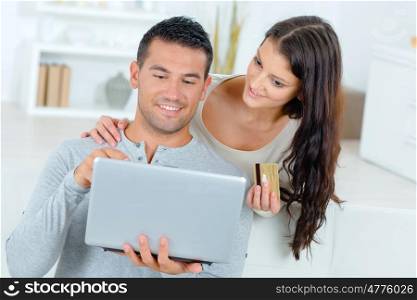 young handsome couple looking into laptop at home