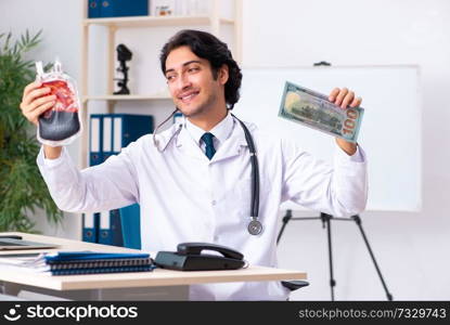 Young handsome doctor in blood transfusion concept 