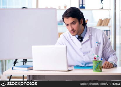 Young handsome doctor in front of whiteboard 