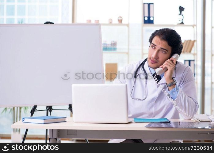 Young handsome doctor in front of whiteboard 