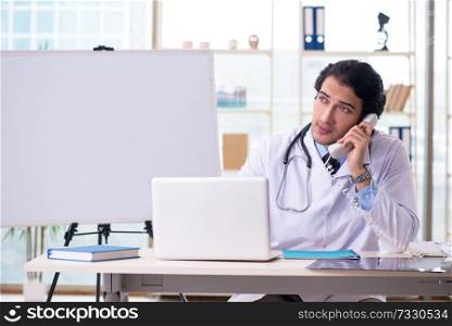Young handsome doctor in front of whiteboard 