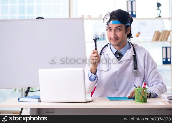 Young handsome doctor otolaryngologist in front of whiteboard 
