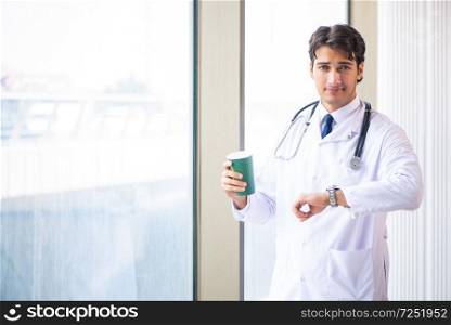 Young handsome doctor standing at the window