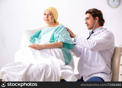 Young handsome doctor visiting female oncology patient 