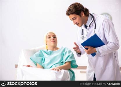 Young handsome doctor visiting female oncology patient 