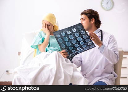 Young handsome doctor visiting female oncology patient